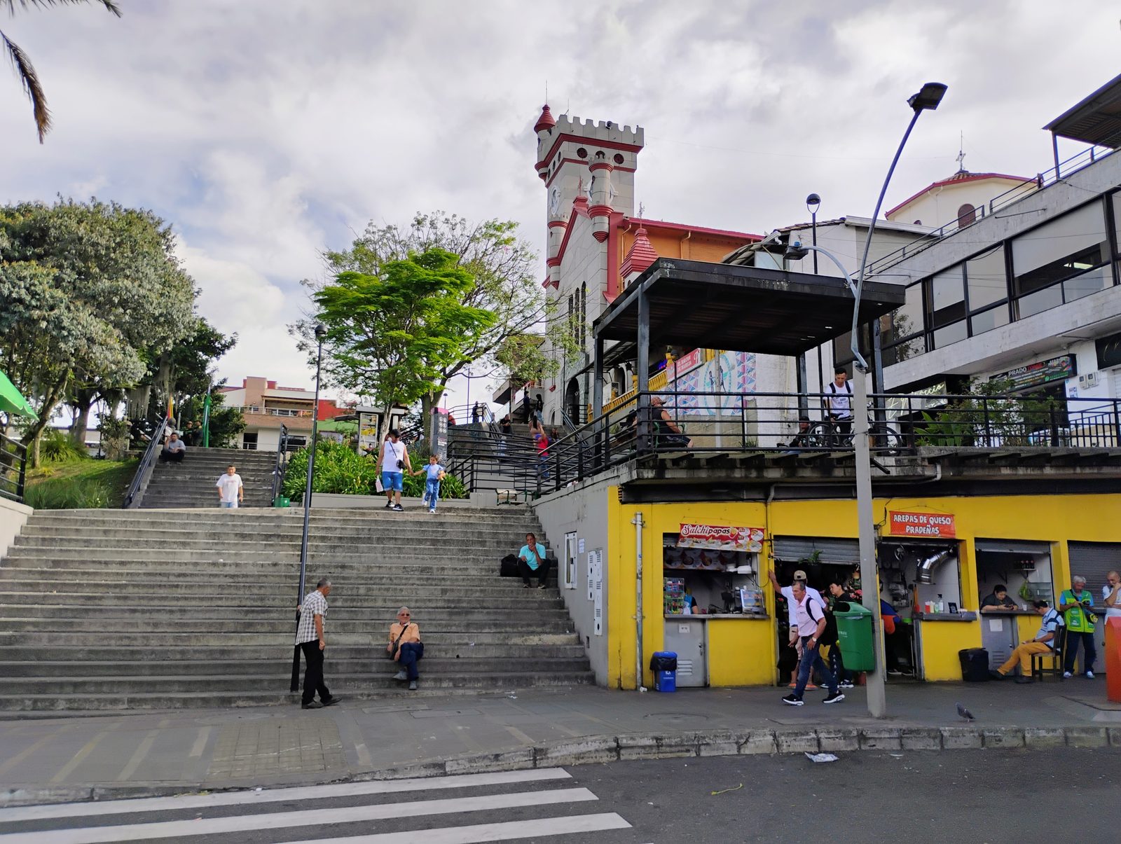 Las gradas del Parque C&iacute;vico con la torre del templo y los kioscos de comida.